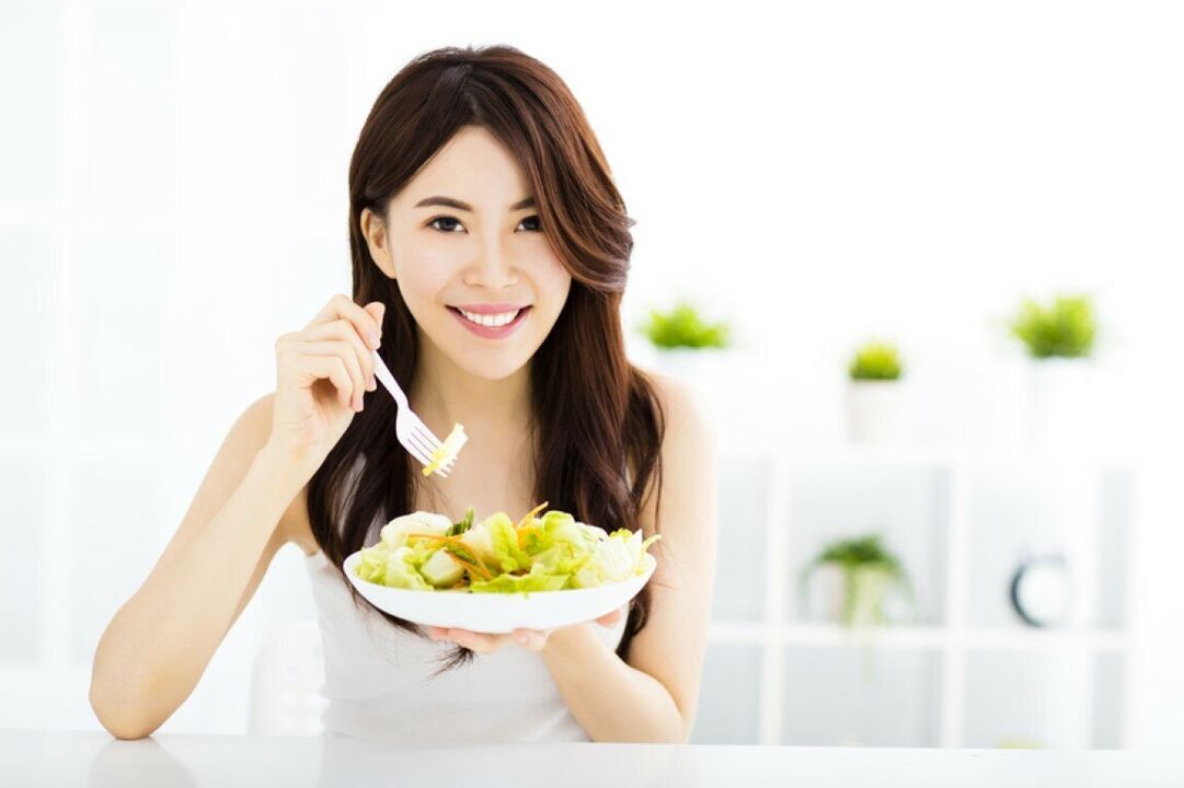 De Japanse vrouw eet een salade